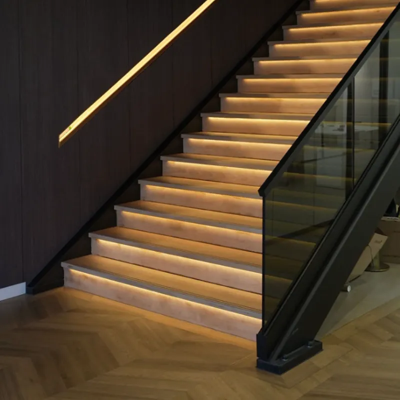Trap met verlichte treden en glazen balustrade