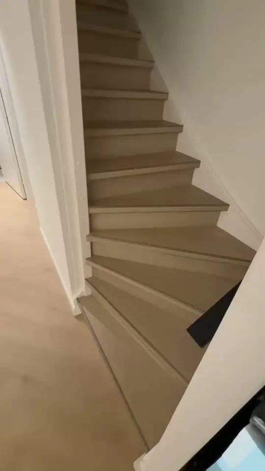 Gerenoveerde dichte trap met lichte treden en trapverlichting